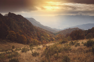 Fotobehang Heuvel Herfstheuvels en bossen bij zonsondergang  © andreiuc88