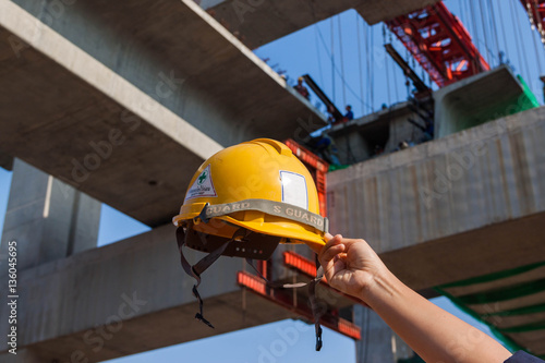 Εκτύπωση καμβά safety helmet in hand with worksite constraction background