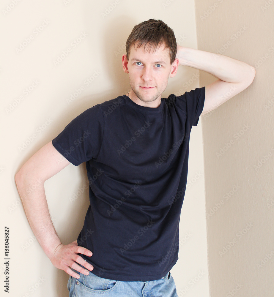 Young man standing in corner in room Young man standing in corner in room