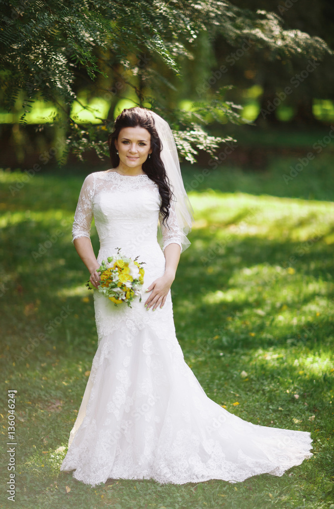 Portrait of the bride in the wedding dress in the park Portrait of the bride in the wedding dress in the park