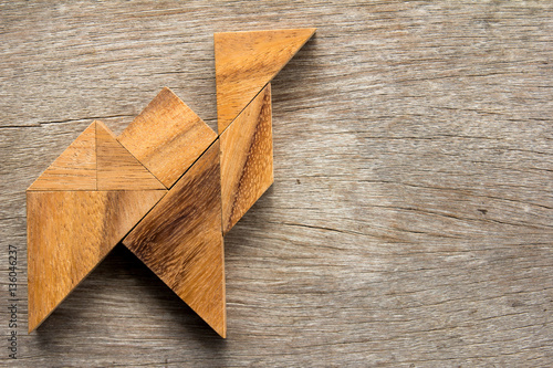 Chinese tangram puzzle in walking camel shape on wooden backgrou