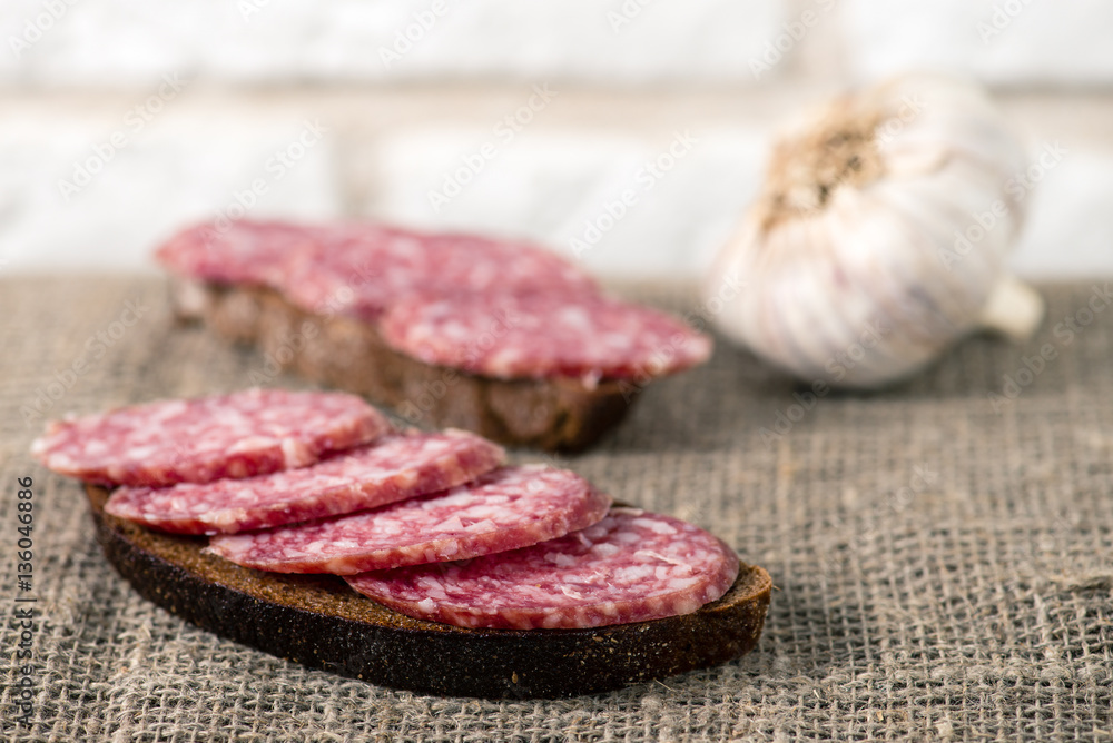 salami sausage sliced with bread on burlap salami sausage sliced with bread on burlap