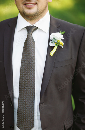 Groom in the black wedding jacket and a tie
