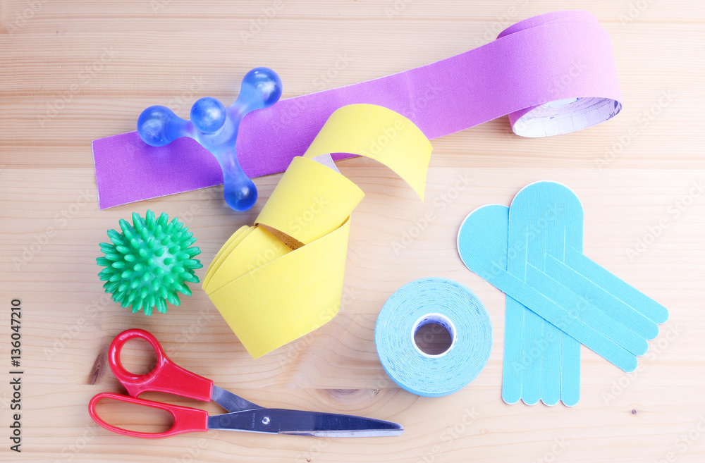Special physio tape rolls on wooden background, closeup. Special physio tape rolls on wooden background, closeup.