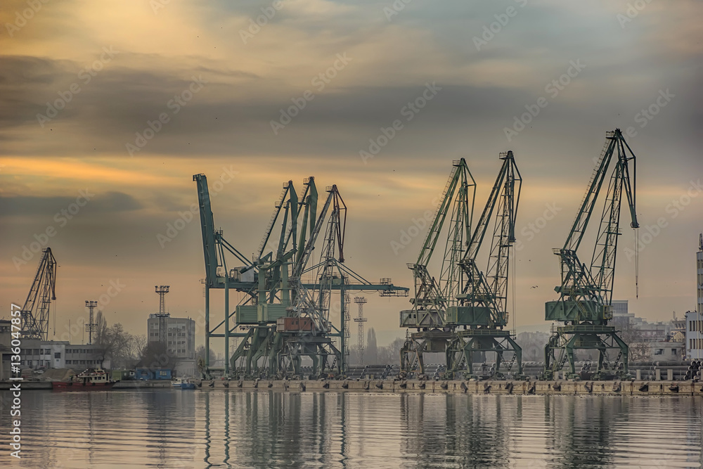 In the evening, the silhouette of port cranes.Ready to load containers from cargo ships.