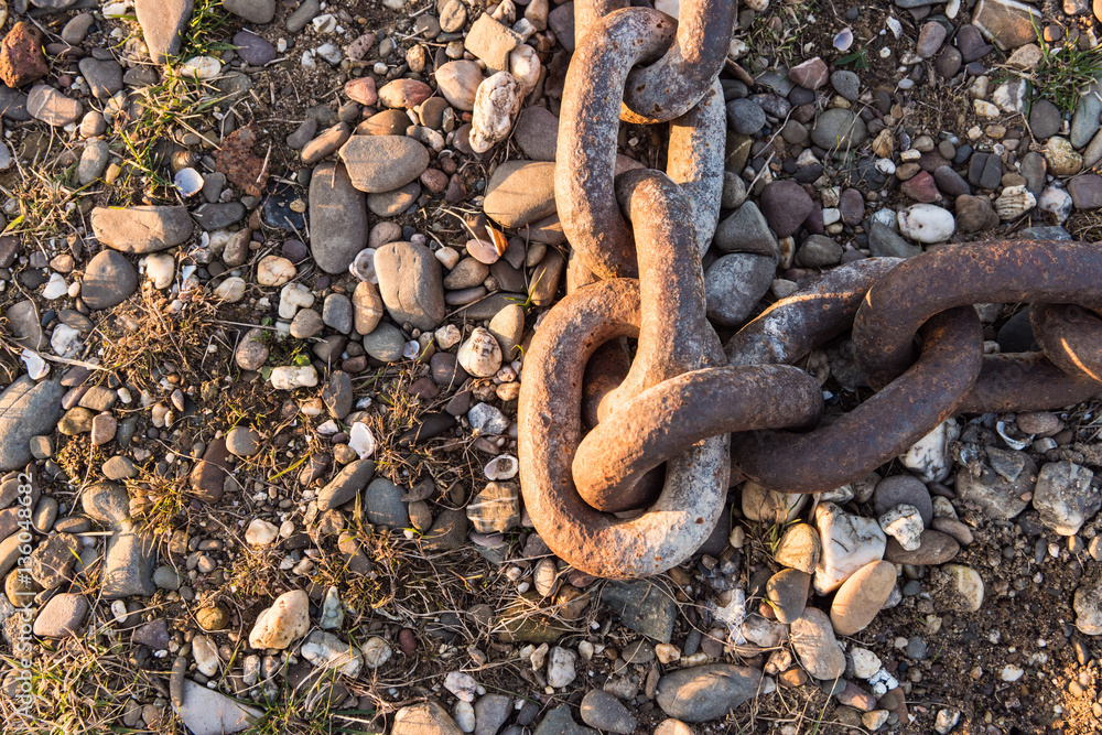 DUESSELDORF, GERMANY - JANUARY 20, 2017: Details of an old anchor chain on the ground are nicely enlighted by the evening sunlight DUESSELDORF, GERMANY - JANUARY 20, 2017: Details of an old anchor chain on the ground are nicely enlighted by the evening sunlight