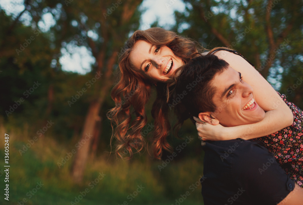 Fototapeta premium The boy carries on hands his girlfriend