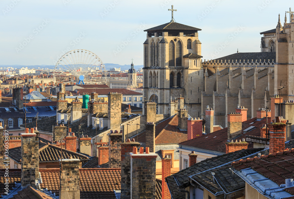 Rooftops and chimneys of the old town Vieux Lyon, with ferris wheel in the background. Lyon, France.