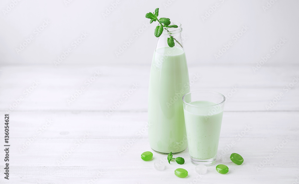 Milk cocktail with mint on a rustic white table Milk cocktail with mint on a rustic white table