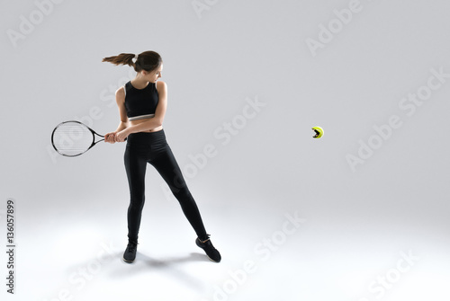 Studio portrait of beautiful girl tennis player with a racket.