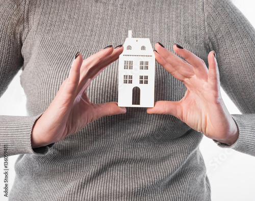 Architecture, building, real estate and property concept . Woman holding house or home maquette.