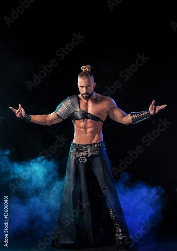 Young and muscular man performing a theatrical pose on  stage. © nazarovsergey