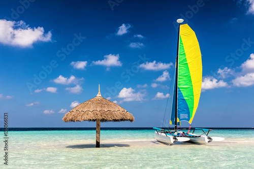 Fototapeta Naklejka Na Ścianę i Meble -  Catamaran on tropical sandbank island with sunshade, Maldives. Indian Ocean