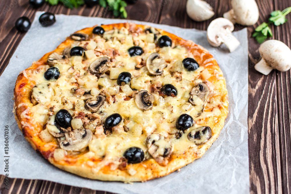 Pizza with meat, mushrooms, pineapple and olives on a wooden background Pizza with meat, mushrooms, pineapple and olives on a wooden background