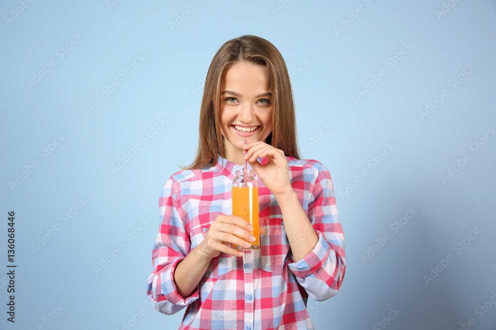 Young beautiful woman with a glass of fresh juice on grey background Young beautiful woman with a glass of fresh juice on grey background