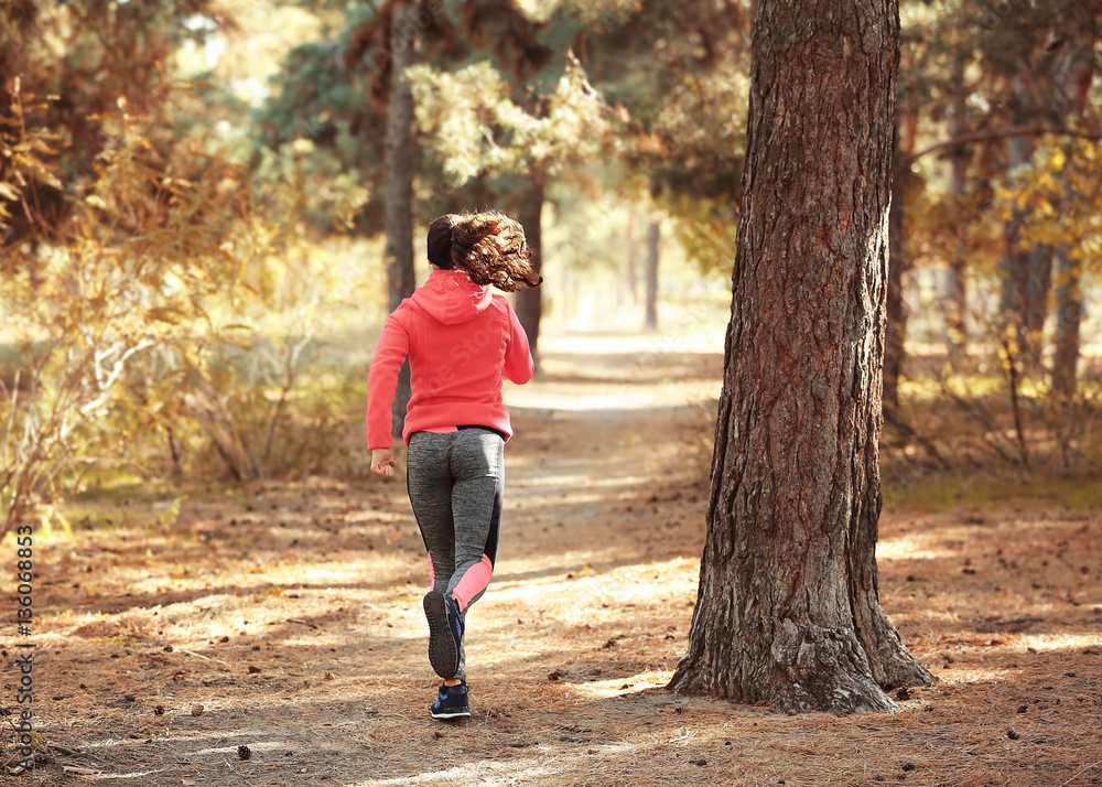 Sporty young woman running in autumn park Sporty young woman running in autumn park