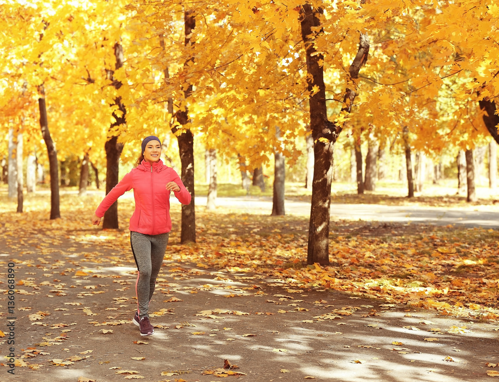 Sporty young woman running in autumn park Sporty young woman running in autumn park