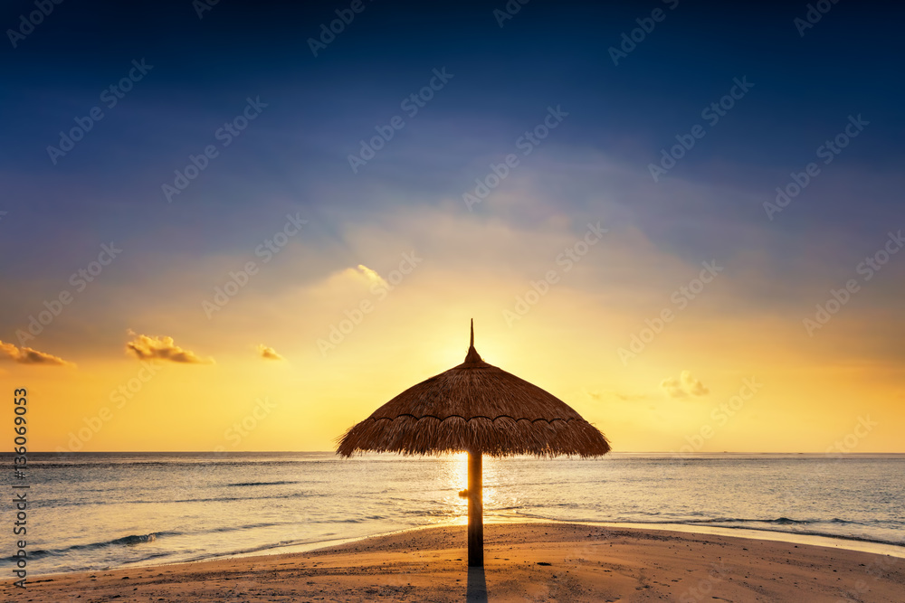 Sunset over tropical sandbank island with sunshade at sunset. Maldives. Sunset over tropical sandbank island with sunshade at sunset. Maldives.