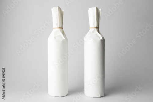 Two wine bottles are standing on gray background