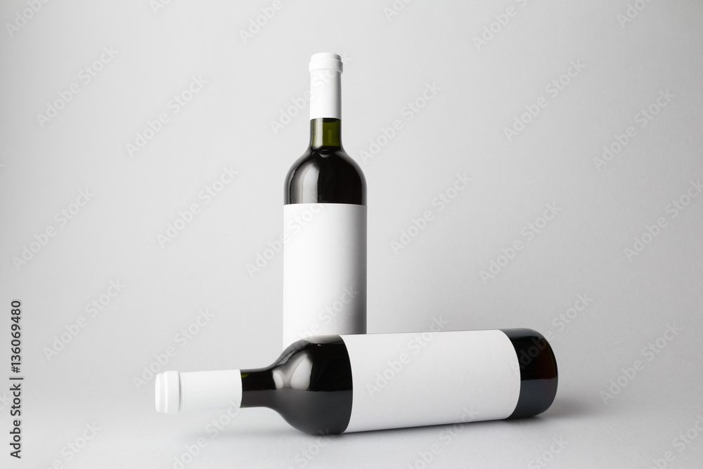 Two wine bottles are standing on gray background Two wine bottles are standing on gray background