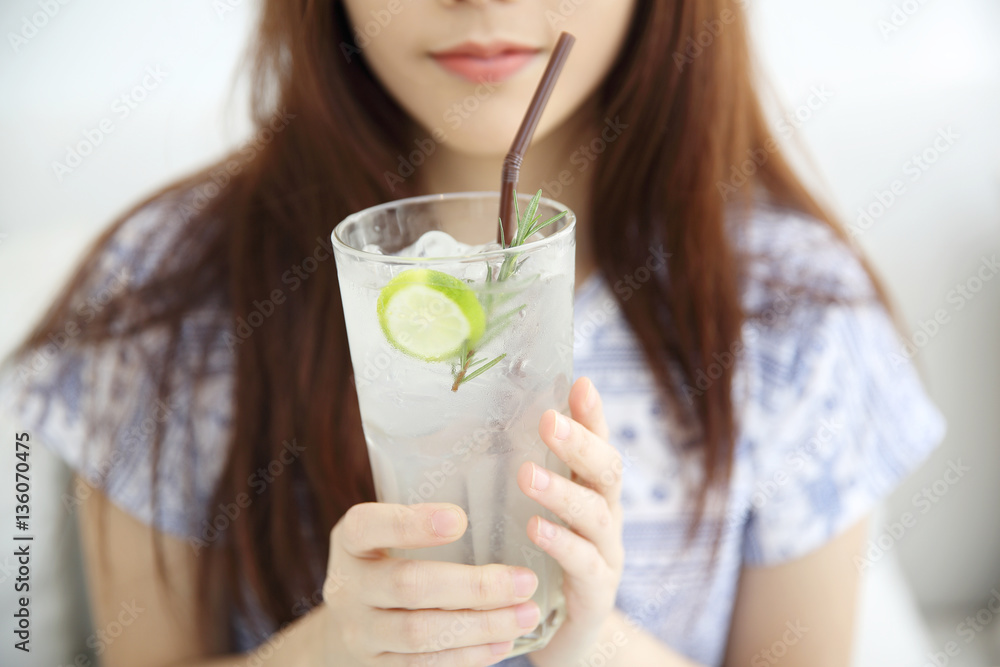 woman drinking lime juice in white coffeeshop
