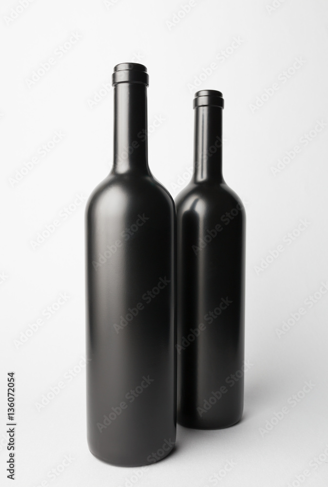 Two wine bottles are standing on gray background Two wine bottles are standing on gray background