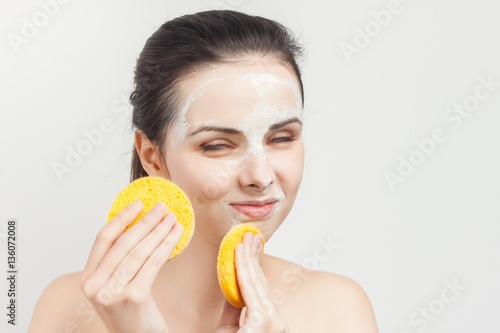 woman wipes the face mask with a soft sponge