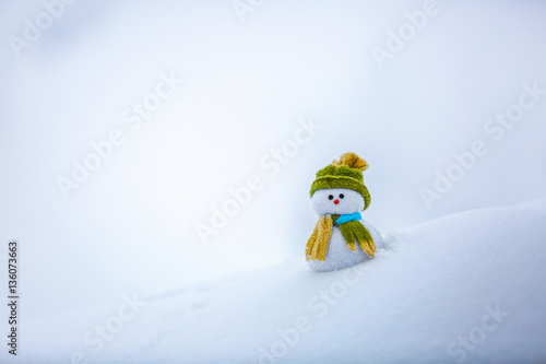 Nice dreaming snowman in green hat. photo