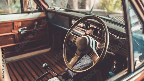 Antique grunge steering wheel in the old car in vintage style picture.