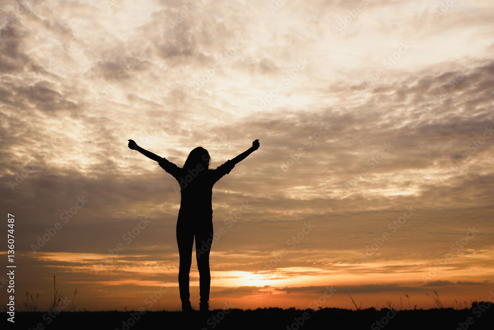 Silhouette of Woman breathing fresh air at sunset background.