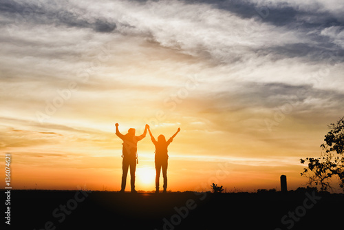 Silhouette couple over sunset background