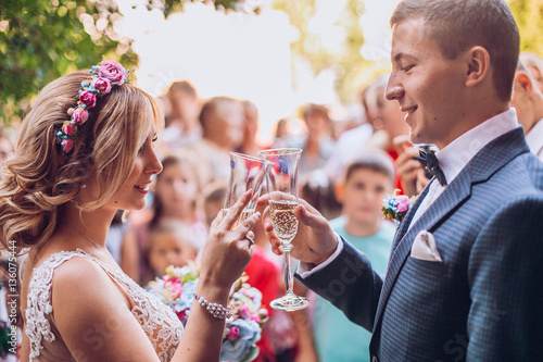 bride and groom posing on the streets of the old city, close to the angle. Drink champagne. Holding glass