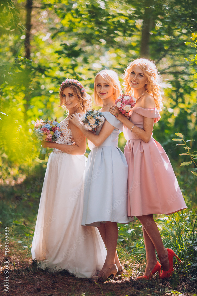 Amazing blond girls. Bride with bridesmaids with flowers hand in medow sunny pine forest. Amazing blond girls. Bride with bridesmaids with flowers hand in medow sunny pine forest.