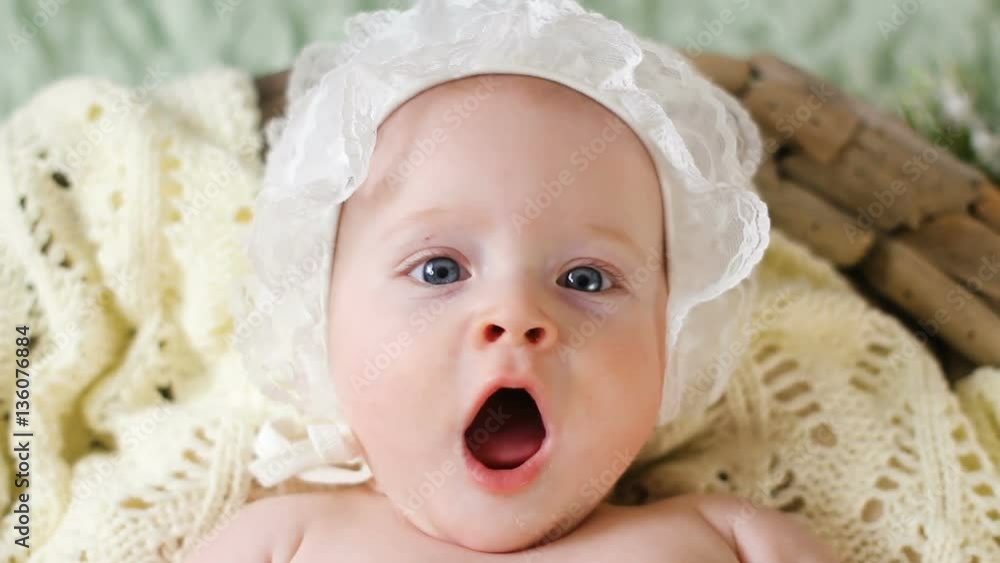 girl kid naked in a white cap lying in the basket and looks at parents girl kid naked in a white cap lying in the basket and looks at parents