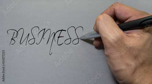 Man hand writing Business on a background