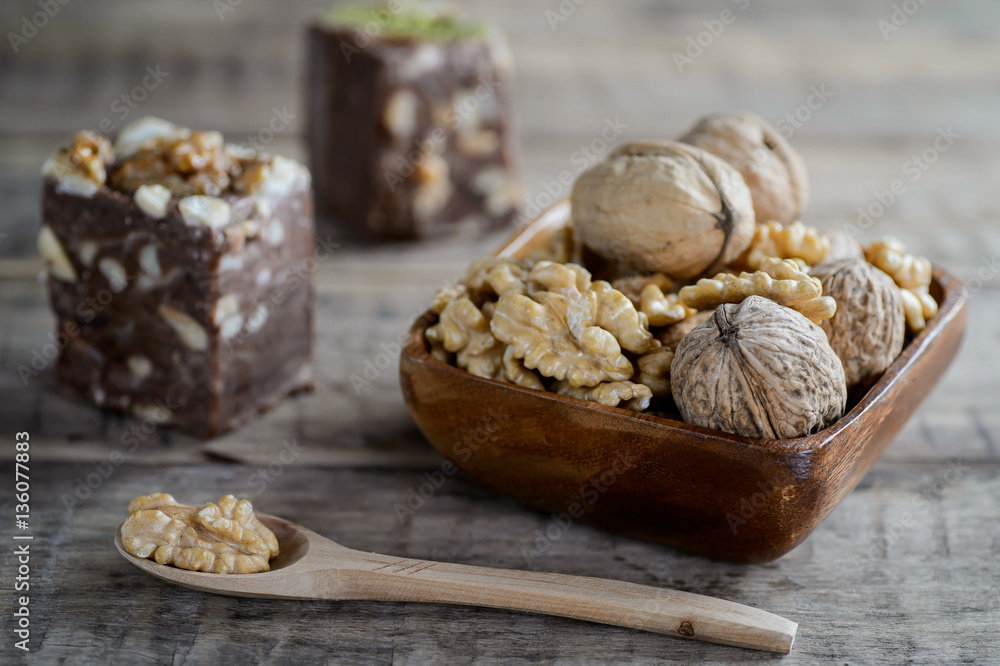 Fototapeta premium walnuts and nut halva on a rustic wooden surface.