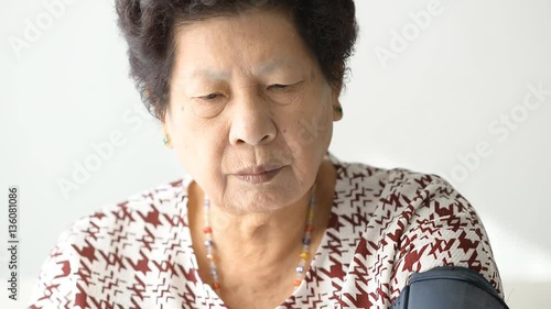 Asian senior woman checking blood pressure  photo