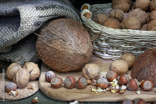 Орехи лежат на старом деревянном столе. Грецкий орех, кокос и фундук