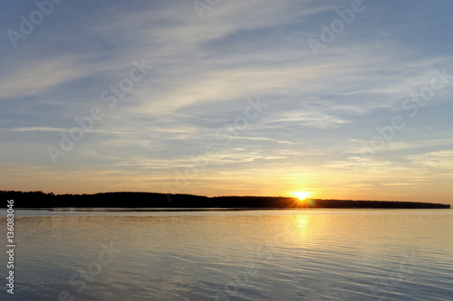 A view of the calm golden sunset on the river with the sun reflected in it  Volga  Russia