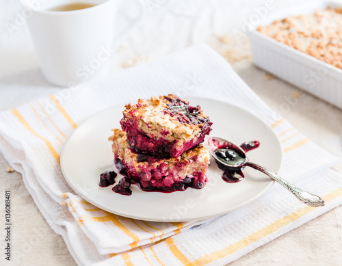 Oat blackcurrant crumble and a cup of tea on a bright background. Eating healthy breakfast concept. 