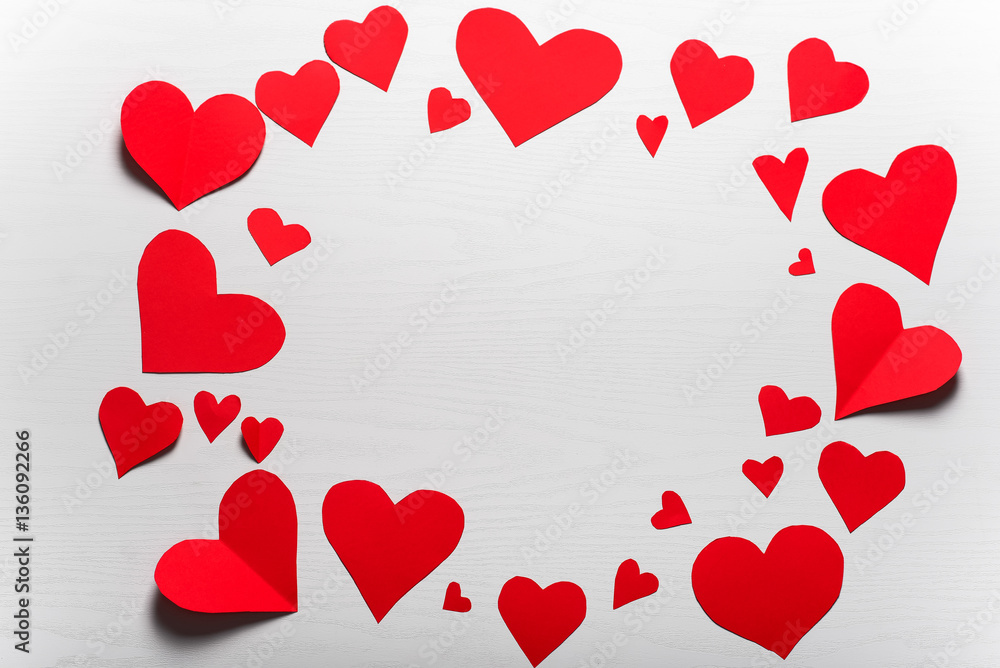 Wooden white background with red hearts. The concept of Valentin