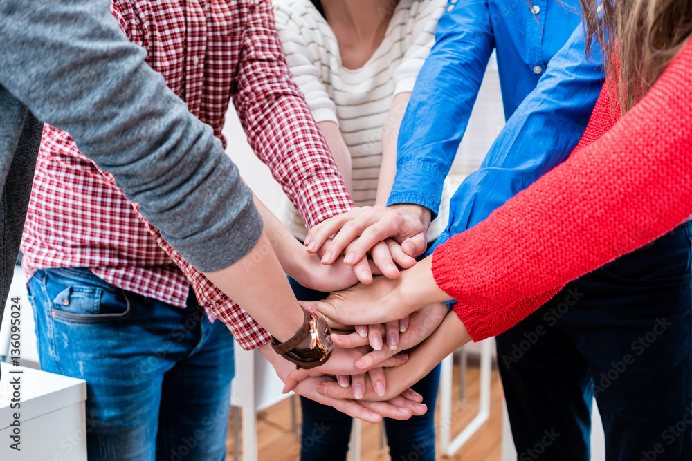 Students in college stacking hand together Students in college stacking hand together