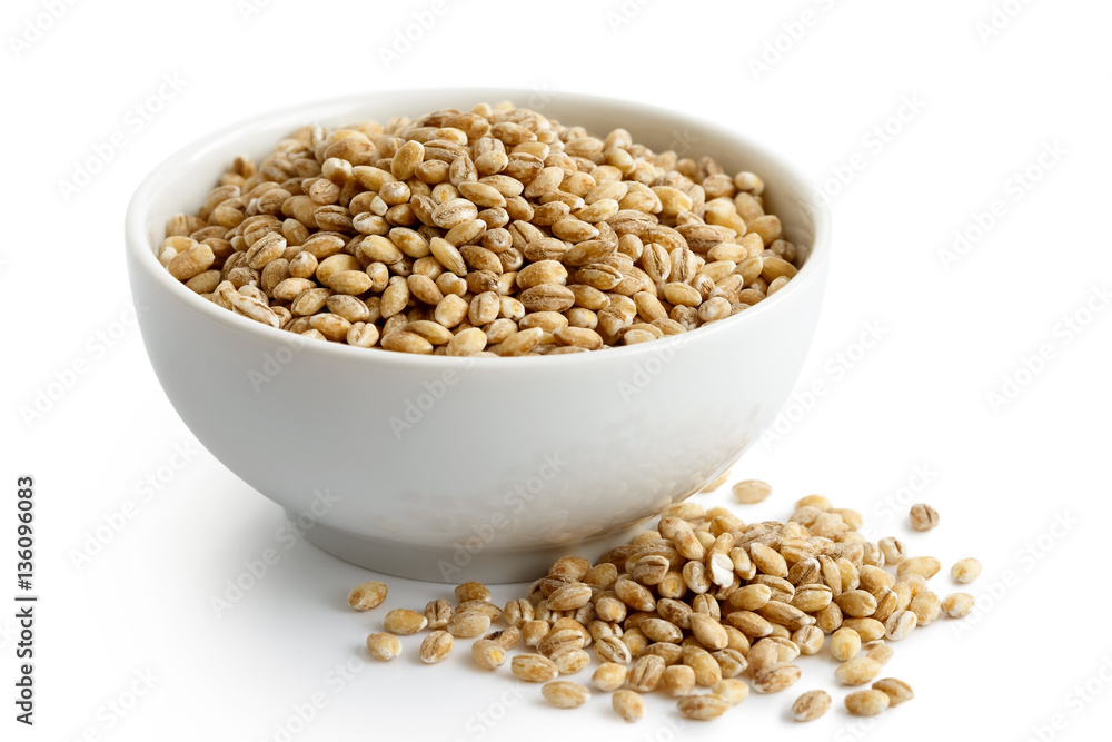 Dry pearl barley in white ceramic bowl isolated on white. 