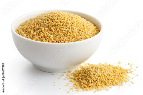 Dry couscous in white ceramic bowl isolated on white. 