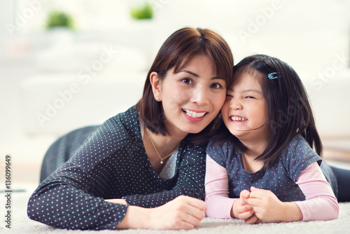 Pretty happy japanese mother play with little daughter at home