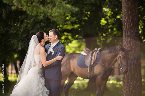 Bride and groom kissing on horse background. Wedding concept © Wedding photography