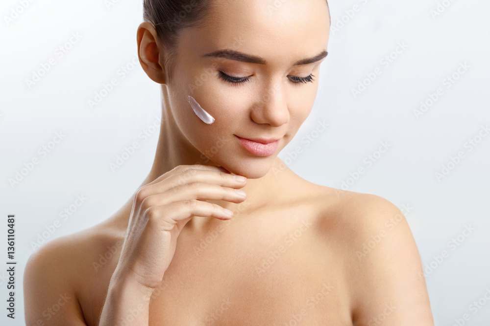 Young girl makes her pretty face fresh and clear with the help of cream.Skin Applying Moisturizing Lotion Young girl makes her pretty face fresh and clear with the help of cream.Skin Applying Moisturizing Lotion