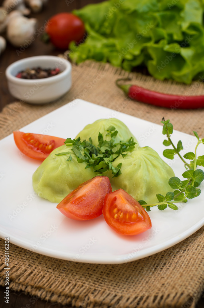Georgian dumplings Khinkali of spinach dough with meat and tomato spicy sauce satsebeli. Wooden background. Top view. Close-up Georgian dumplings Khinkali of spinach dough with meat and tomato spicy sauce satsebeli. Wooden background. Top view. Close-up