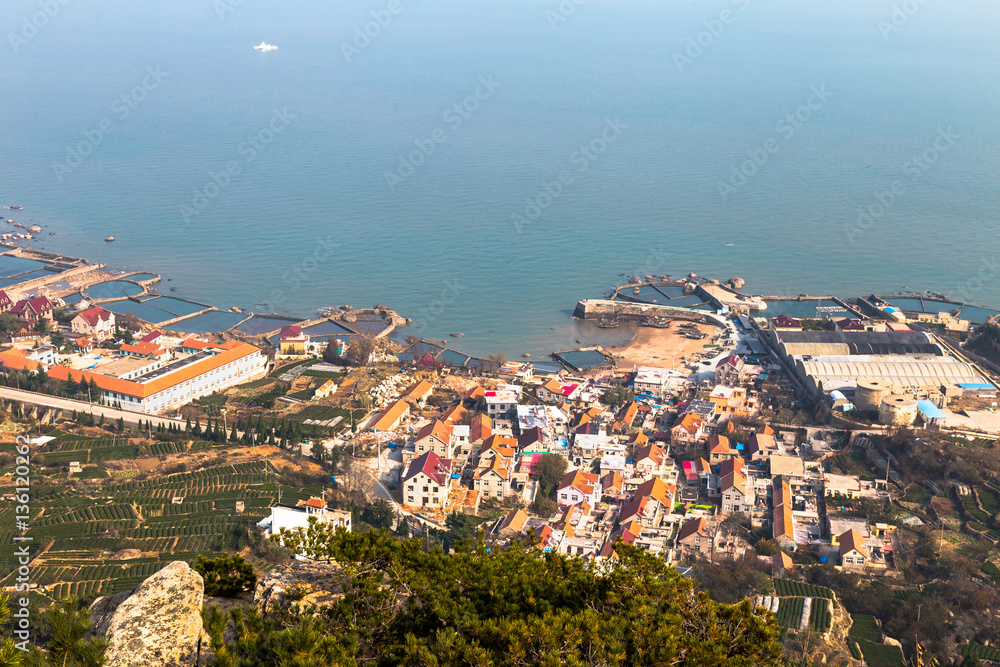Fototapeta premium Fishing villages on the coast of Laoshan Mountain seen from Na Luo Yan Ku trail, Qingdao, China