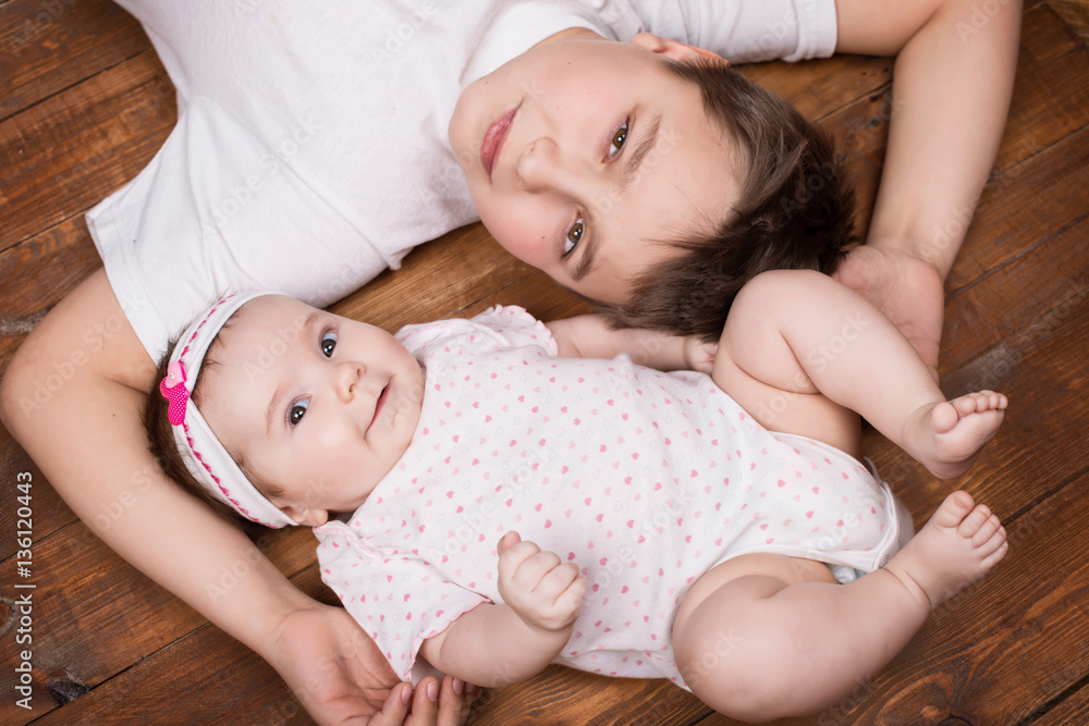 Brother hugging his newborn sister. View from above Brother hugging his newborn sister. View from above